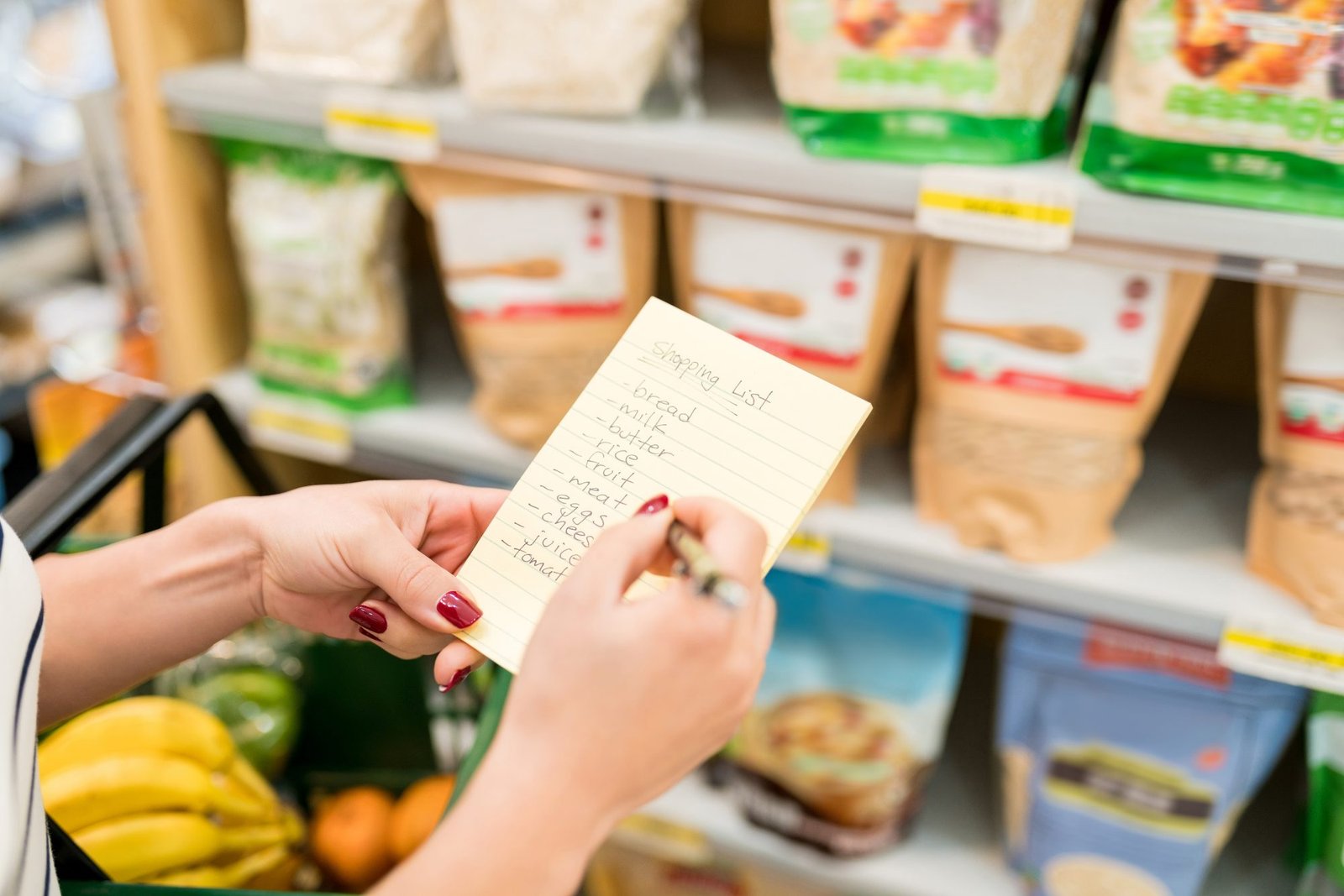 Personne complétant sa liste de courses dans un rayon de supermarché